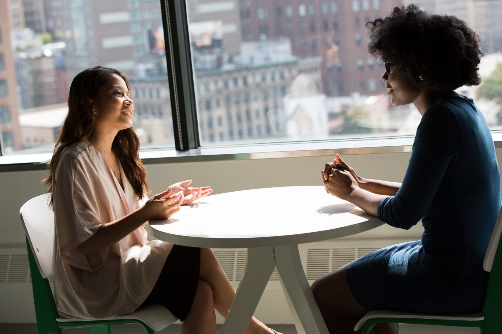 Two women talking to each other over a table